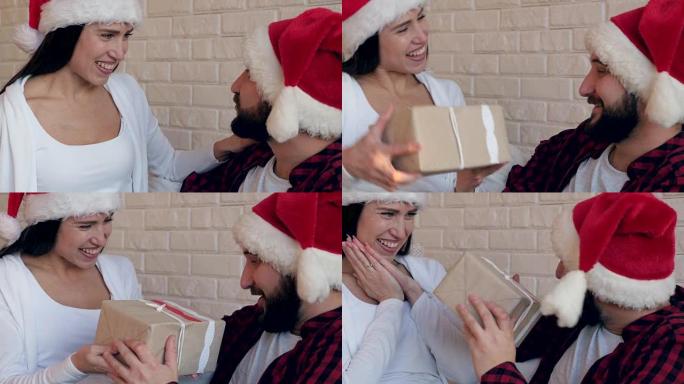 戴着圣诞老人帽子的幸福夫妇坐在椅子上送礼物