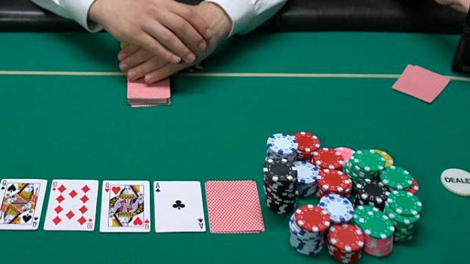 扑克玩家看着他的牌，自信地提高赌注，合理的风险
