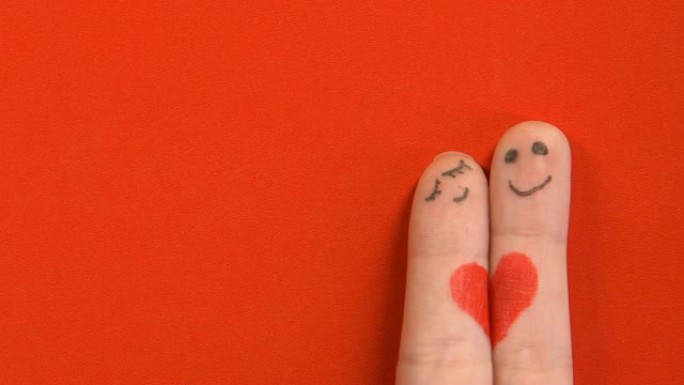 两个手指脸与彩绘的心拥抱，浪漫关系，爱情概念
