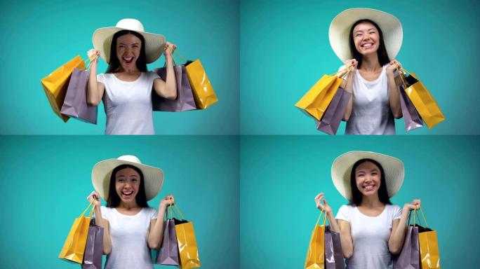 巴拿马开朗的亚洲女孩拿着许多纸袋，购物，女性爱好
