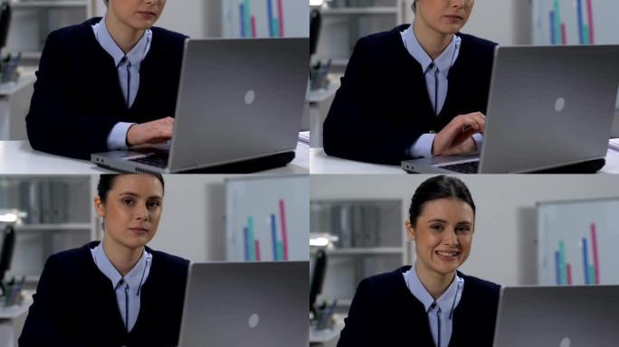 美丽的年轻女子在办公室工作笔记本电脑微笑相机，商业生涯