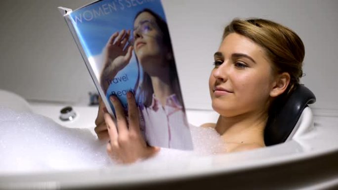 美女在泡澡里读杂志，晚上放松