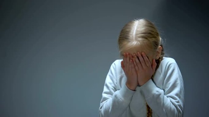 不幸的小孩用手闭上眼睛，欺凌和家庭暴力受害者