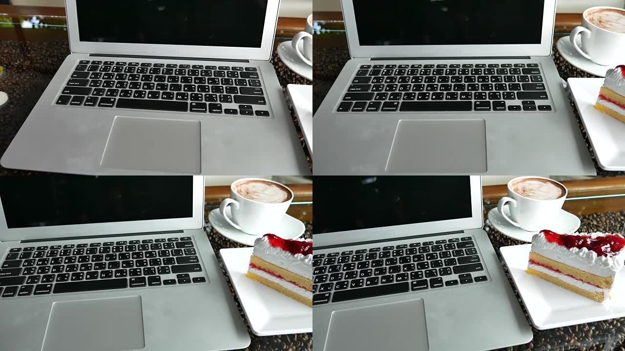 咖啡咖啡厅的笔记本咖啡和草莓蛋糕
