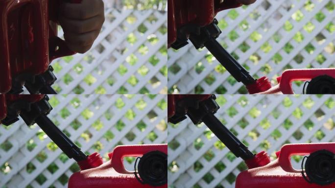 一名西班牙裔男子的手在户外将汽油倒入红色塑料汽油罐中的特写镜头