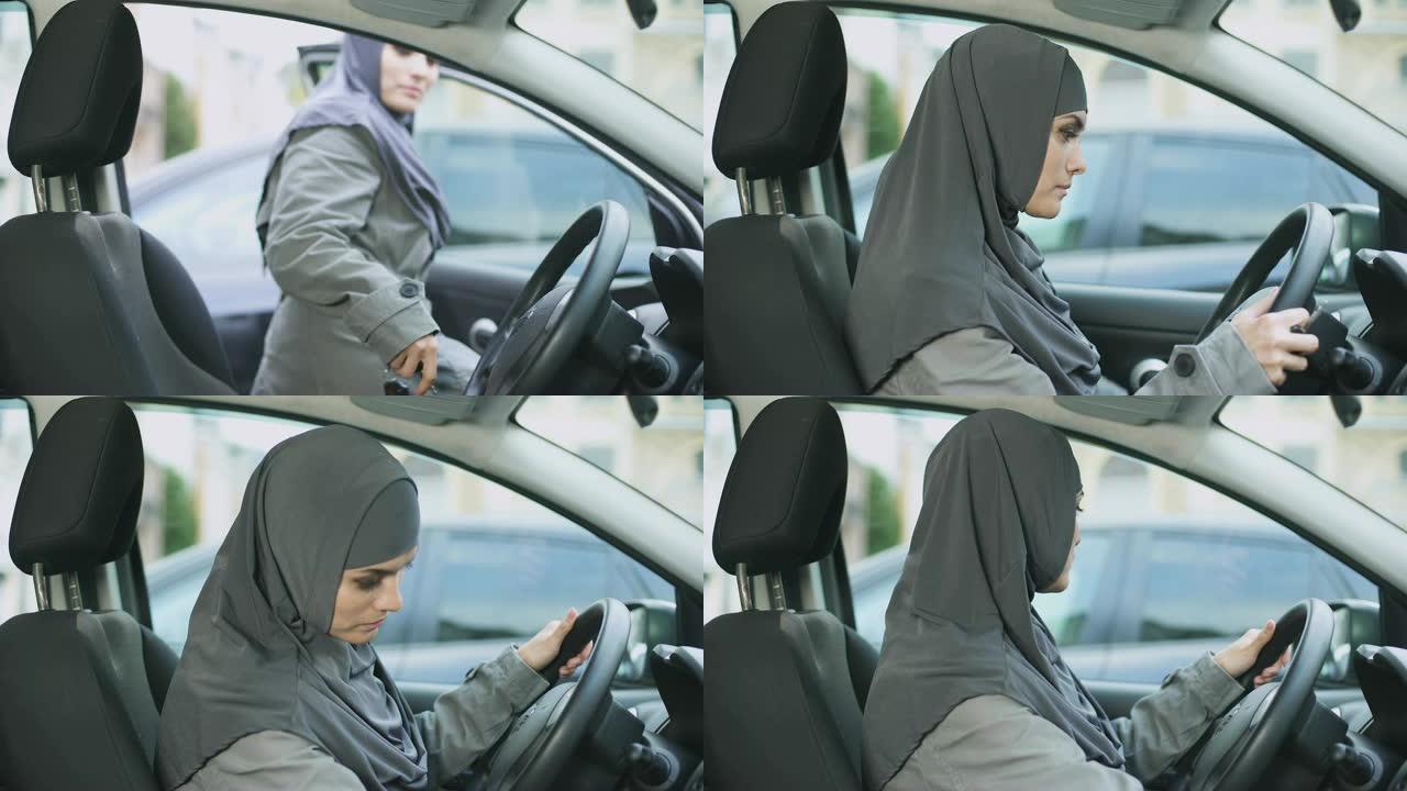 穆斯林妇女坐在汽车启动引擎，看着后视镜驾驶执照