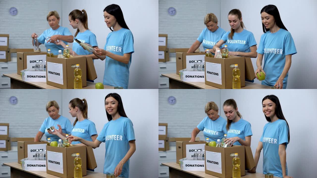 穿着志愿者t恤的快乐妇女放罐头食品盒，捐赠