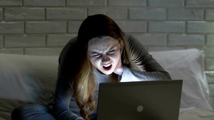 女性晚上在床上工作笔记本电脑，颈痛，姿势不好