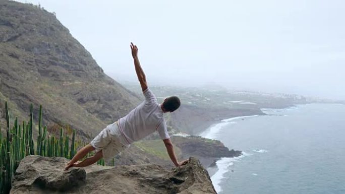 一个人站在山上，背对着镜头，看着海洋，沉思在加那利群岛。