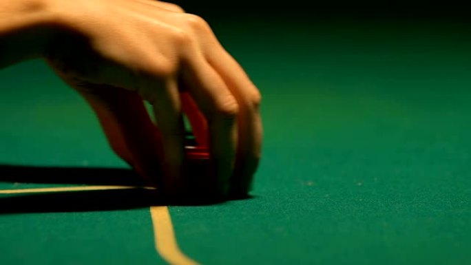 女人将最后的扑克筹码放在游戏桌上，进行全押，特写