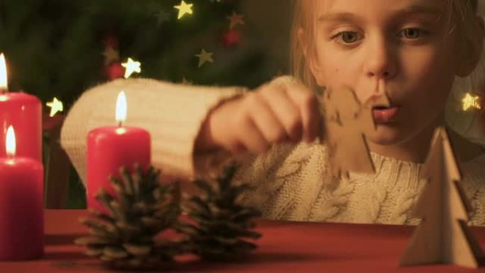 女孩玩松果和木制圣诞玩具，节日气氛