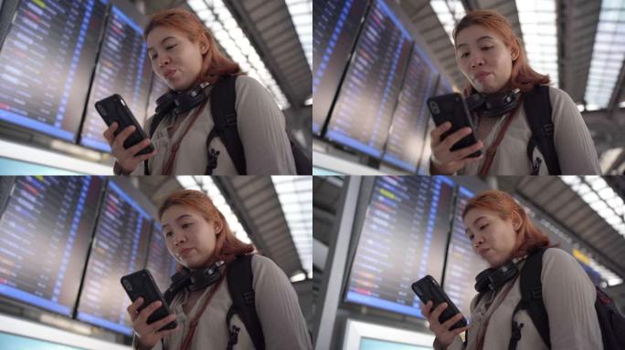 4k镜头女性乘客在机场的航班信息显示系统在线办理登机手续。