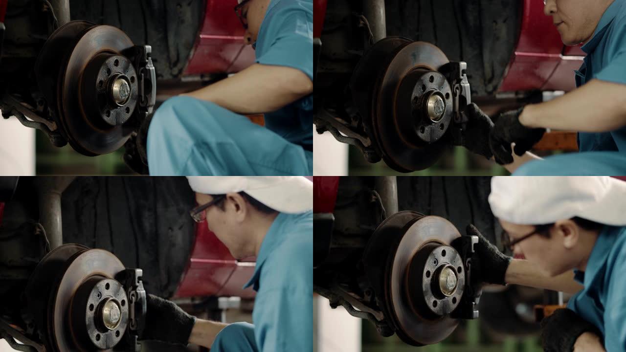 机械师在车间更换汽车上的刹车片