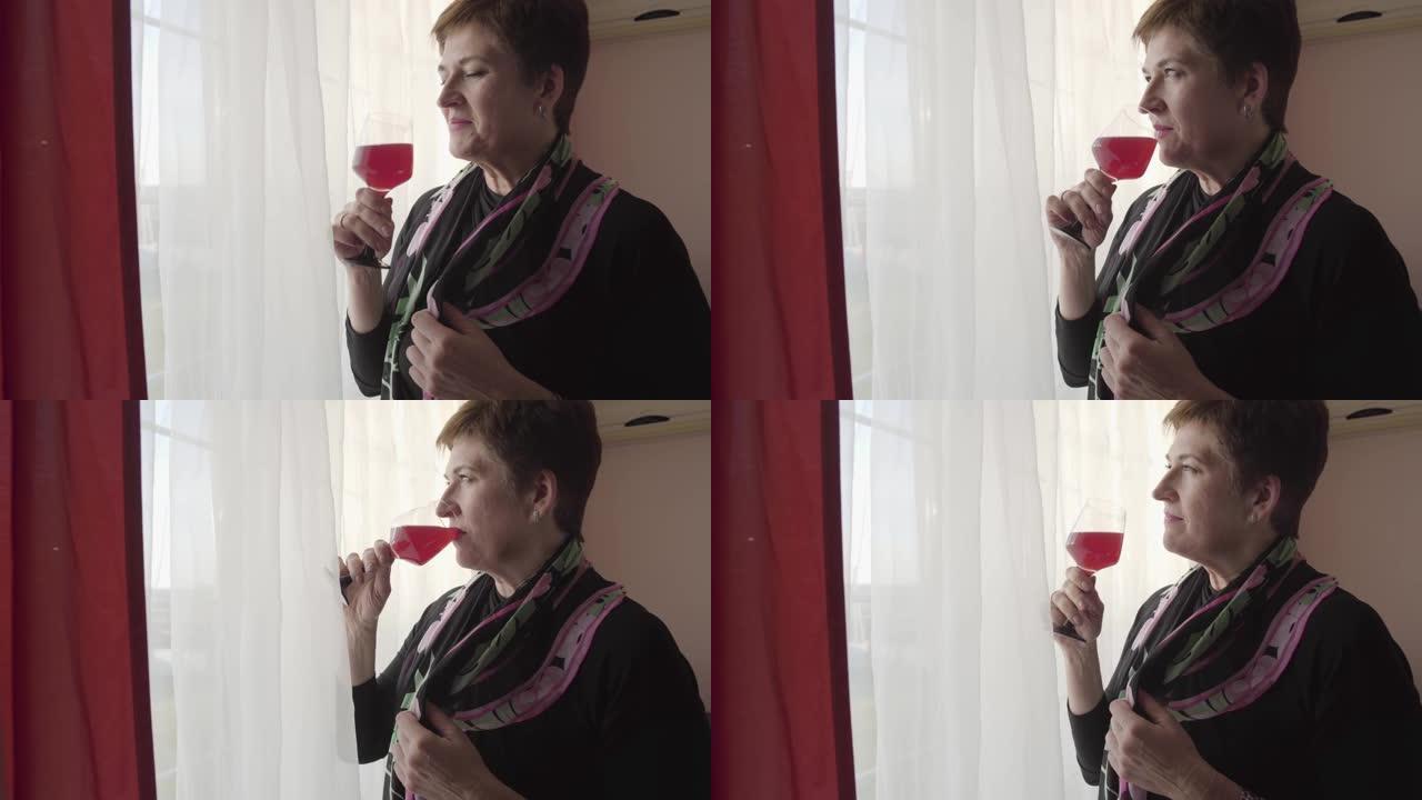 高级商人喝红酒。美丽的高加索女人站着一杯酒，看着窗户。自信，休息。休闲。