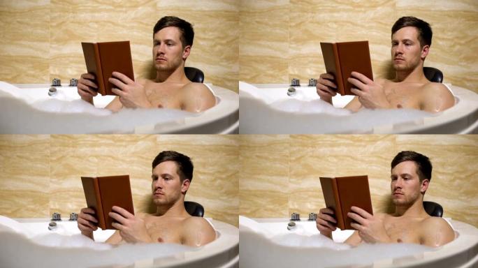 男人花时间放松在舒适的泡沫浴和阅读有趣的书