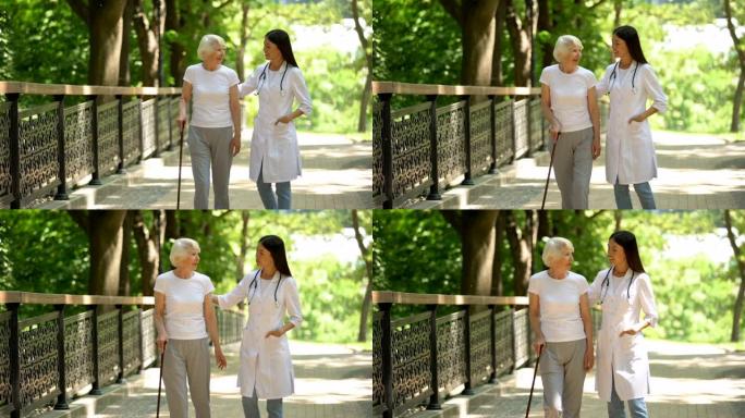 医生与老年女性手杖患者一起在公园散步，康复