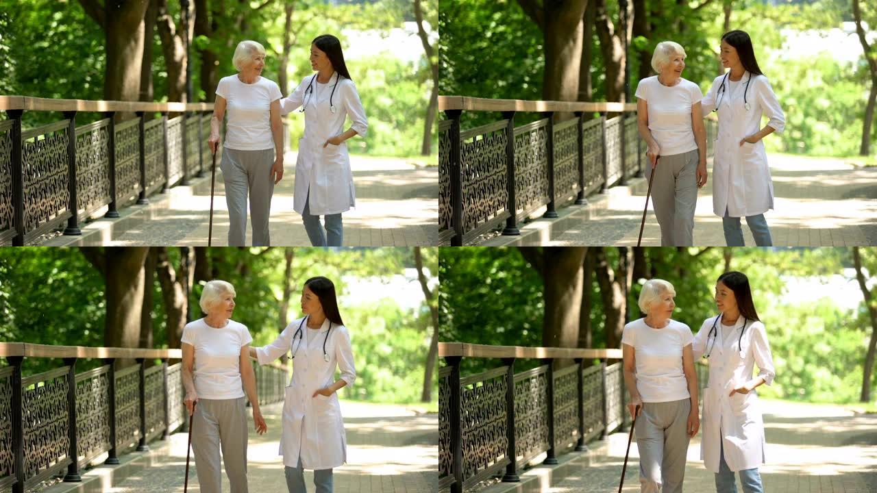 医生与老年女性手杖患者一起在公园散步，康复