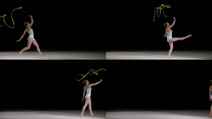 SLO MO LD艺术体操运动员一边跳一边旋转金丝带