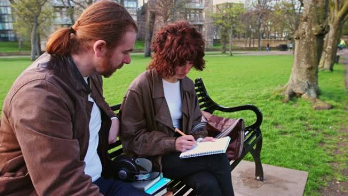两名研究生在公园长凳上讨论工作的慢动作镜头