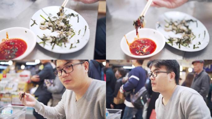 亚洲年轻人在韩国首尔市街头食品市场美味地用筷子吃章鱼触手