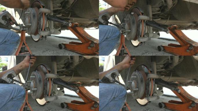 4K: 汽车机械师在汽车车轮制动盘上工作，并在汽车上更换刹车片