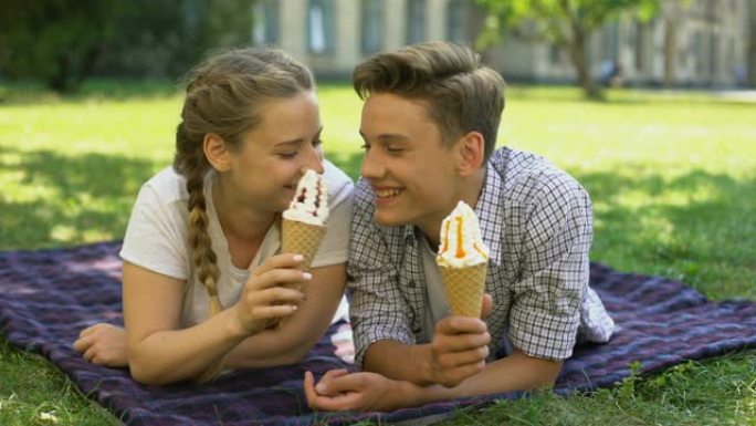 有趣的青少年互相喂冰淇淋，躺在格子上，鬼混