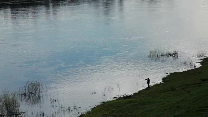 渔夫在河中钓鱼的轮廓的远程视图