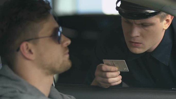 警察检查车内男子的驾驶执照，执勤警察交通规则