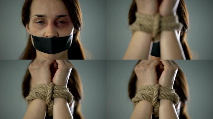 被绑的女人用恐惧的眼神看着镜头，被绑架的受害者，奴隶