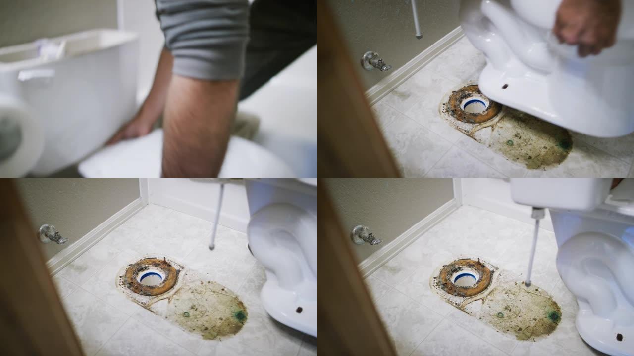 一名穿着凉鞋的高加索修理工抬起瓷器马桶，露出室内家庭浴室下面的肮脏地板和蜡环