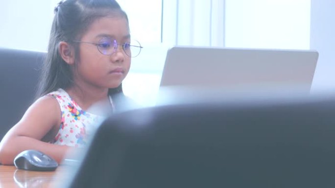 使用笔记本电脑的亚洲小女孩。