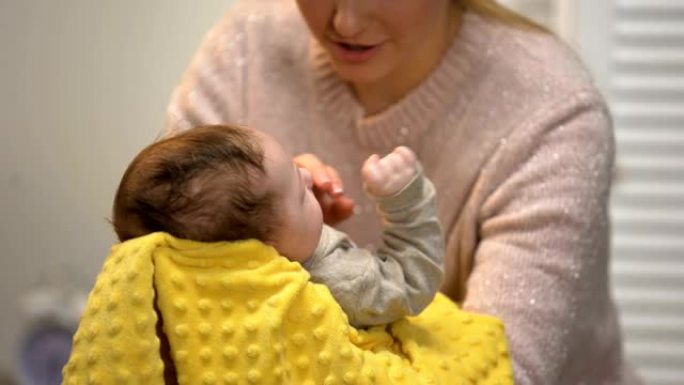 年轻的妈妈拍拍新生儿肚子以减少婴儿绞痛，婴儿保健