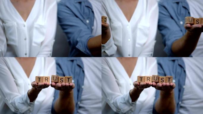 恋爱中的夫妇在手握着的木制立方体上连接信任词，家庭