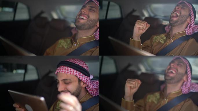 阿拉伯中东男子在车内使用数字平板电脑观看体育比赛