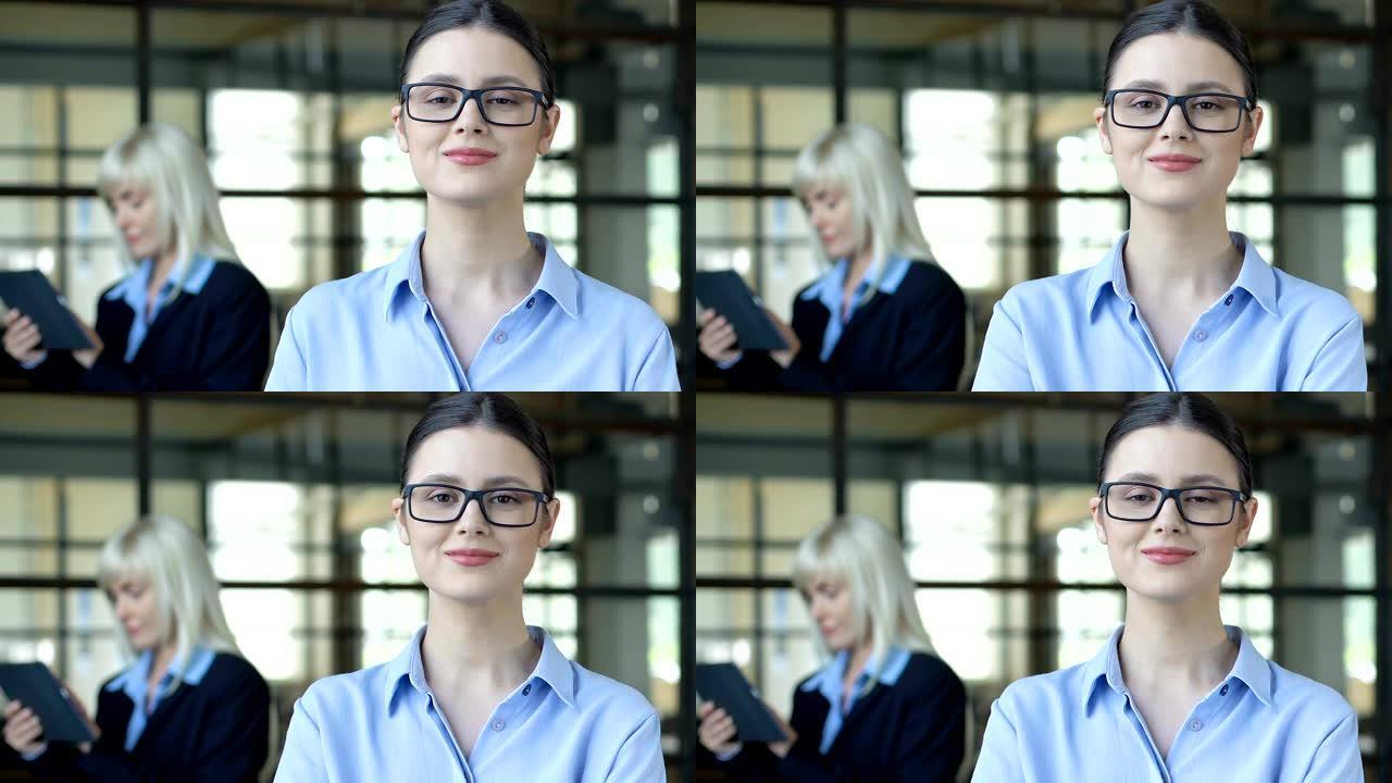 戴着眼镜的聪明女人在镜头前摆姿势，雇佣了年轻的专业人士