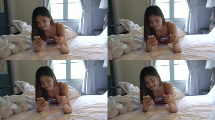 4k镜头的女人在床上使用智能手机进行在线购物