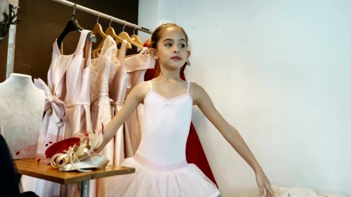 芭蕾小女孩在架子上选择衣服