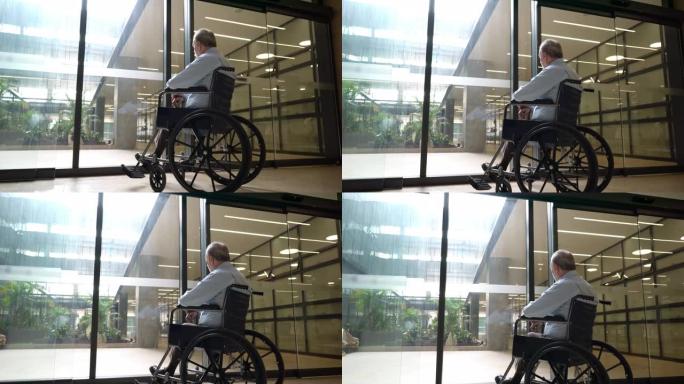 老人坐在轮椅上透过玻璃门眺望的背景图