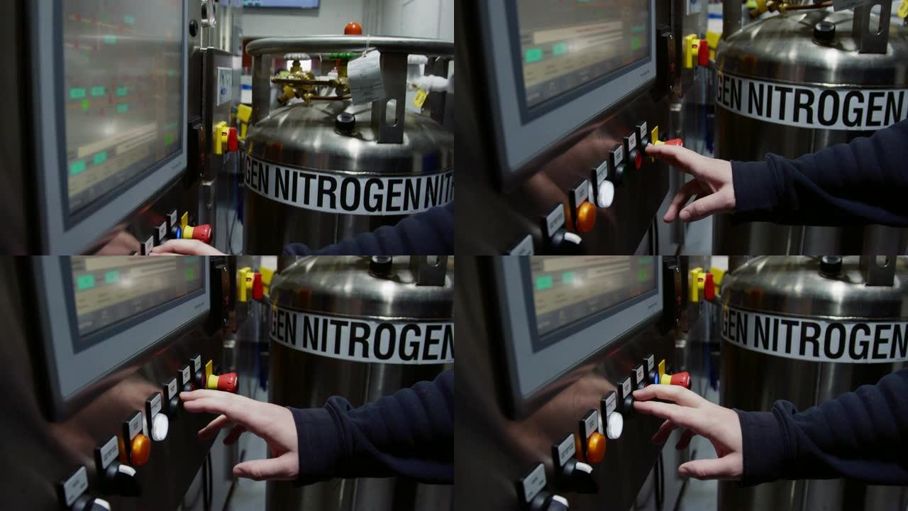 高加索人在室内制造设施中按下液氮罐旁边的按钮