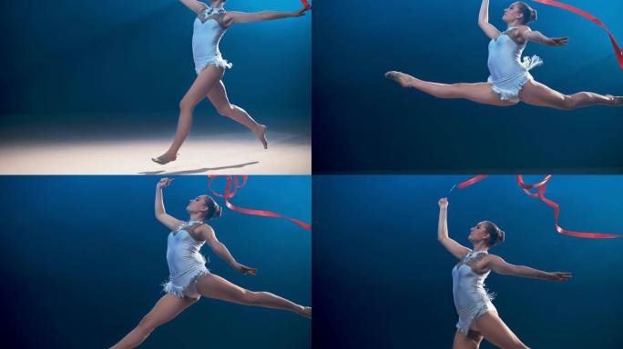 SLO MO SPEED RAMP艺术体操运动员在空中旋转时进行了一次跳跃，她的红丝带在空中旋转