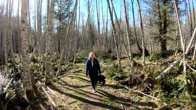 成熟的女性徒步旅行者遵循森林之路