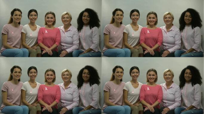 带着粉红丝带的女性意识到乳腺癌，对着镜头微笑，健康