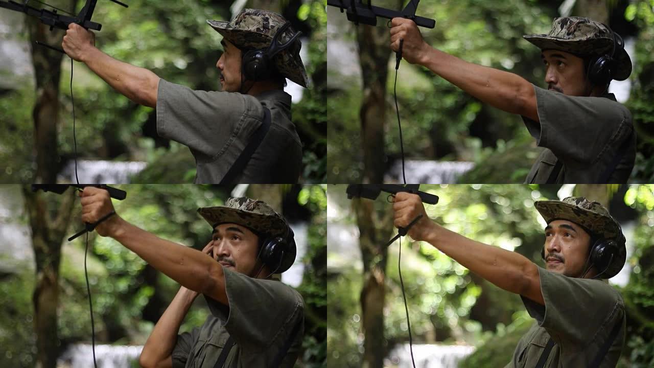 研究人员收听来自无线电遥测的无线电信号，跟踪寻找热带雨林中的野生动物
