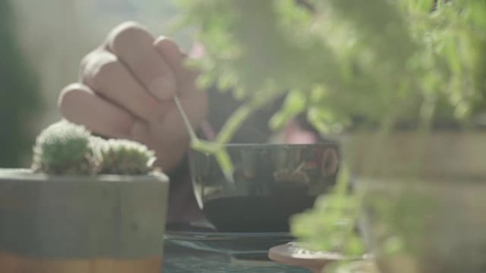 男性手在杯子里用一勺咖啡搅拌
