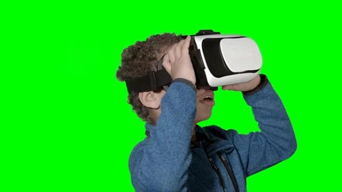 高清: 使用虚拟现实模拟器的小男孩