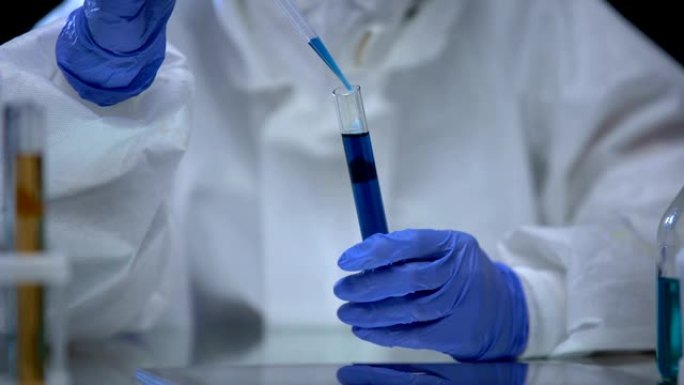 有毒实验室的科学家检查蓝色电离辐射液体危险样品