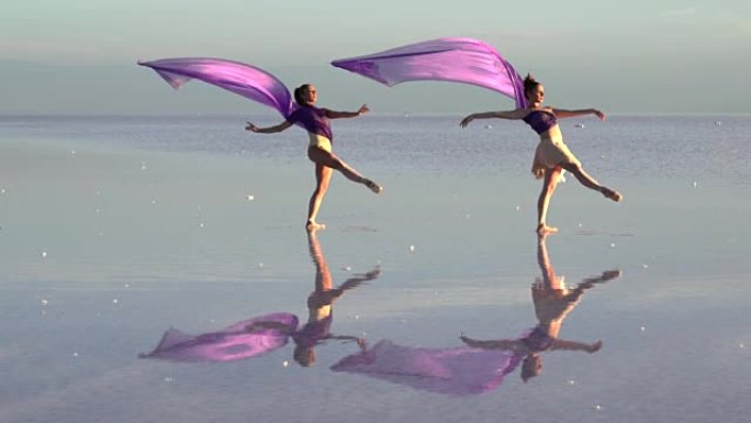 年轻的芭蕾舞演员用彩色薄纱在盐湖上跳舞
