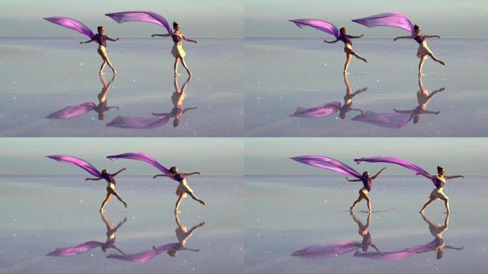 年轻的芭蕾舞演员用彩色薄纱在盐湖上跳舞