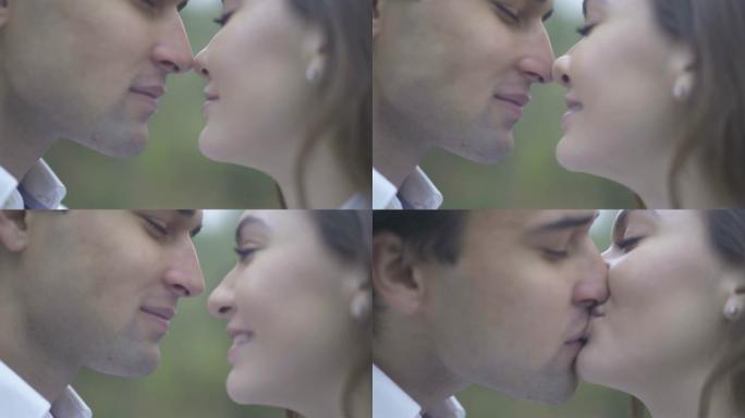 一对年轻夫妇亲吻男性和女性的特写镜头擦鼻子，亲吻男人和女朋友在一起的情侣相爱幸福的情侣