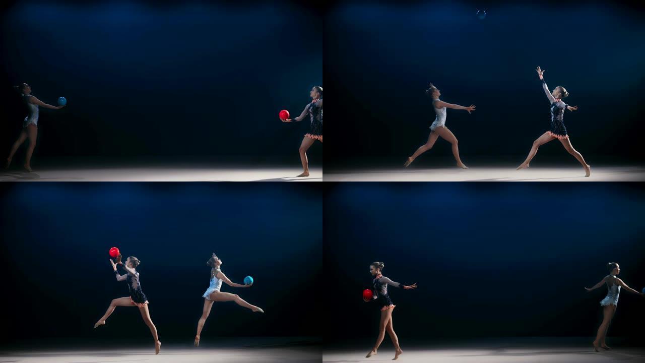 SLO MO两个相对的艺术体操运动员在将球抛向空中的同时进行了一次跳跃
